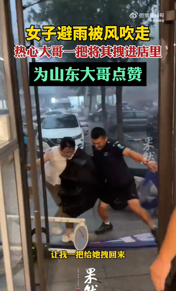 大哥将险被吹走女子拉进店里